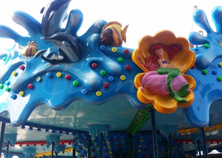 Top decorations of the carousel featuring a mermaid and sea creatures in vivid fiberglass designs.