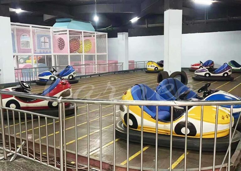 Ground grid bumper cars neatly arranged in indoor playground with safety fences