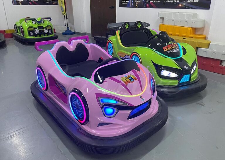 Close-up of pink and green kids battery bumper cars with bright LED lights.