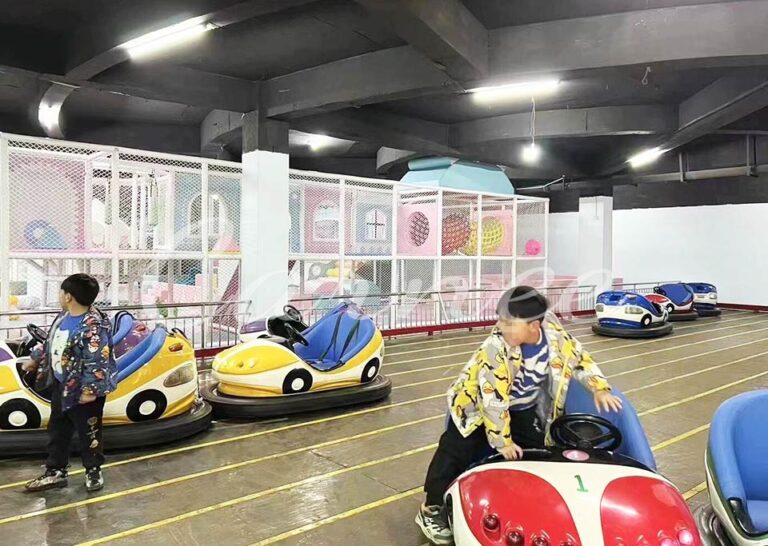 Kids playing on ground grid bumper cars at indoor amusement park