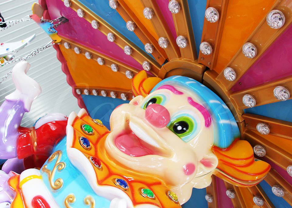 Colorful central clown figure with LED lights on the flying chair ride