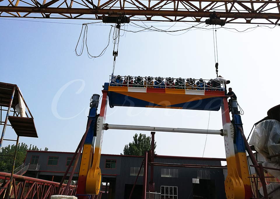 Top Spin ride cabin being lifted during installation by industrial crane outdoors