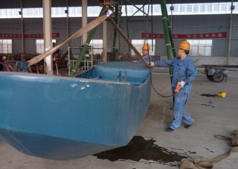 Workers lifting and assembling steel cabin of 12 seat mini pirate ship amusement ride