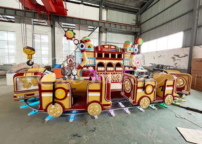 Colorful urban firefighting heroes track train ride with lights and steam effects at a theme park.