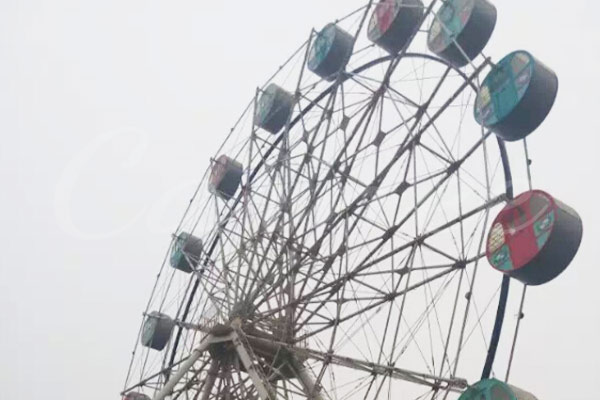 Vintage Ferris wheel with colorful cabins, showcasing a classic amusement park ride.