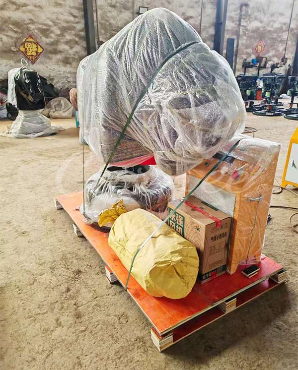 Mechanical bull ride parts securely wrapped for shipping on a wooden pallet, ready for export.