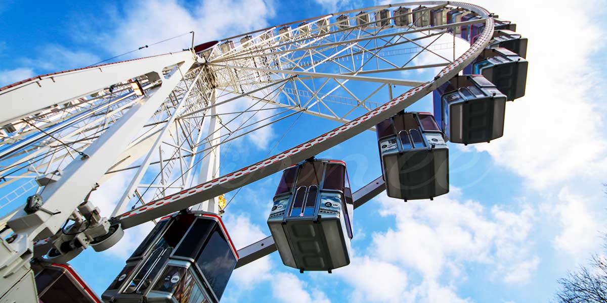 Ferris wheel illuminated at night, symbolizing advanced monitoring technology and safety systems for optimal performance.