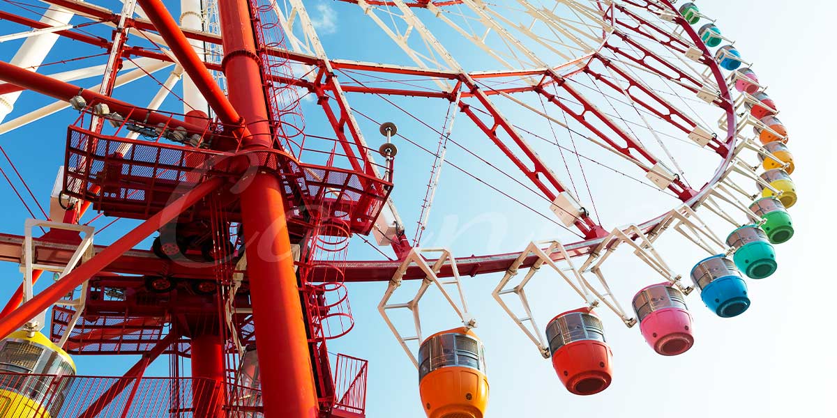 Red Ferris wheel with visible safety features, emphasizing the importance of regular inspections for safe amusement rides.