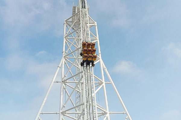 Vertical lift roller coaster carriage at peak height before free fall drop