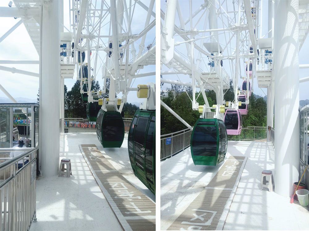 Close-up of the 66m Ferris wheel's station, featuring colorful cabins ready to board with a clear view of the surroundings.