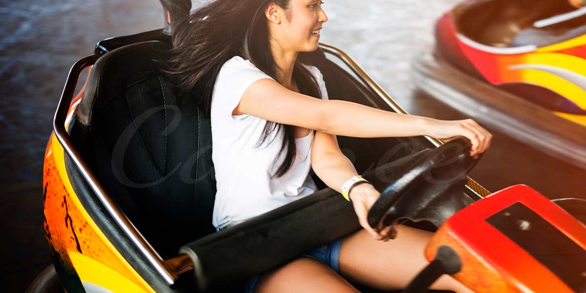 Families and kids enjoying a bumper car ride at an amusement park with colorful lights.
