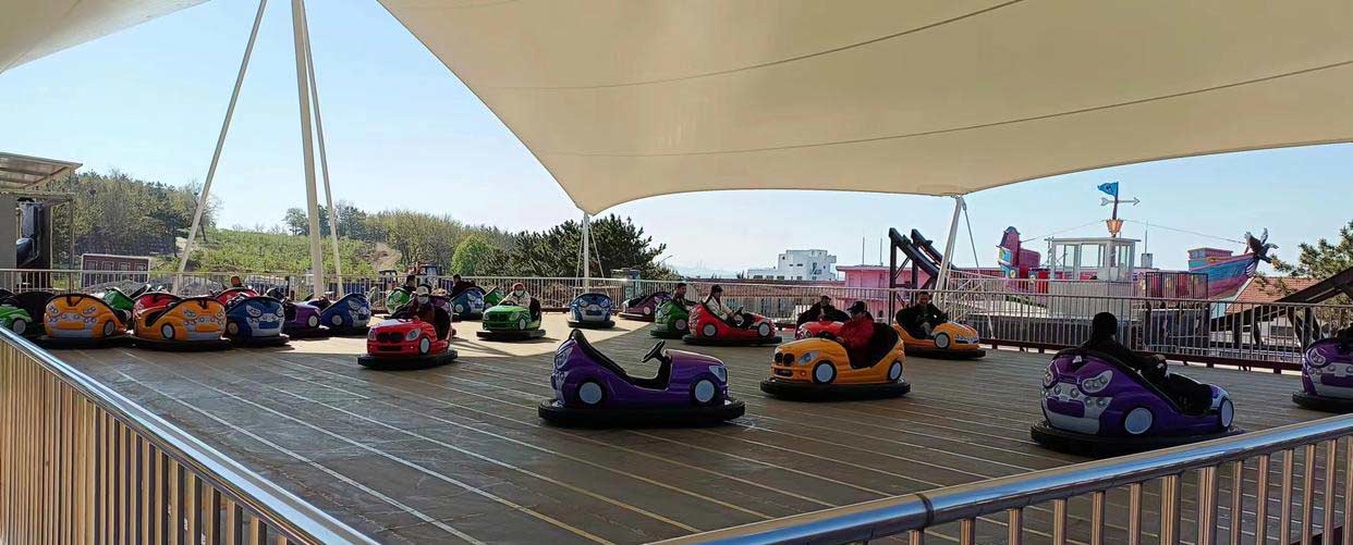 A vibrant array of colorful bumper cars lined up in an amusement park, ready for fun rides.