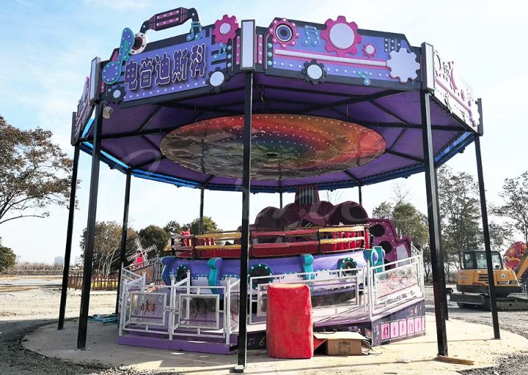 Electric Disco Tagada Ride in a colorful theme park setting, featuring sound system panels and vivid exterior design.