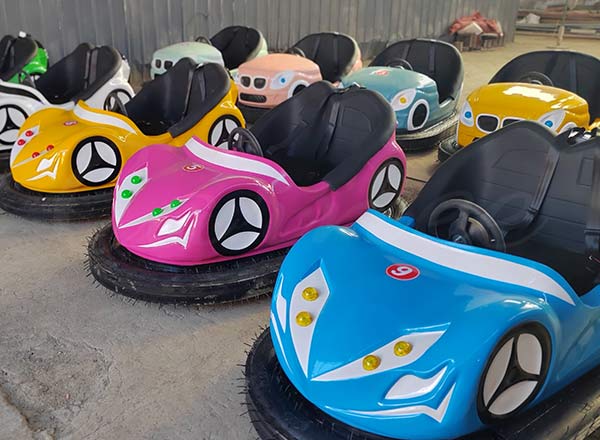 Children’s bumper cars in colorful designs, available in blue, pink, and yellow for amusement rides.