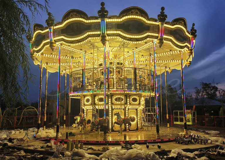 Night view of double decker carousel with 38 seats, illuminated two-story merry go round for funfair and park attractions