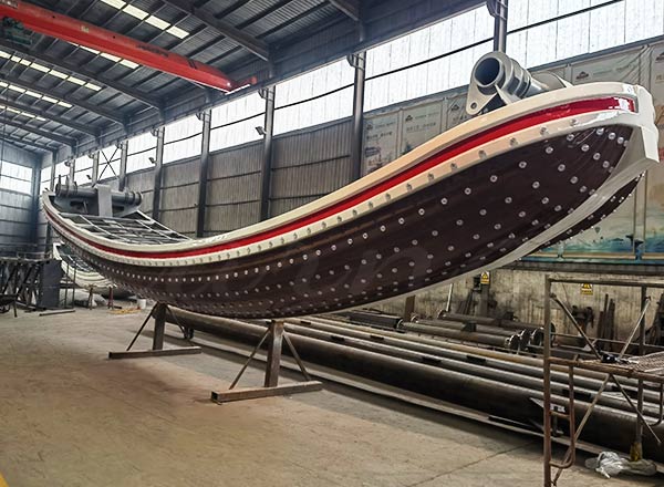 Large pirate ship ride fiberglass body under factory production and welding process.