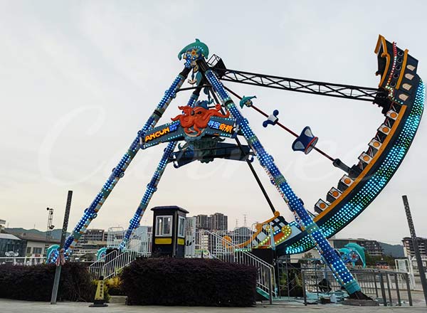Colorful pirate ship amusement ride with LED lights operating at night in amusement park