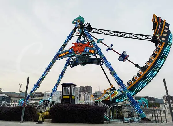 Colorful pirate ship amusement ride with LED lights operating at night in amusement park
