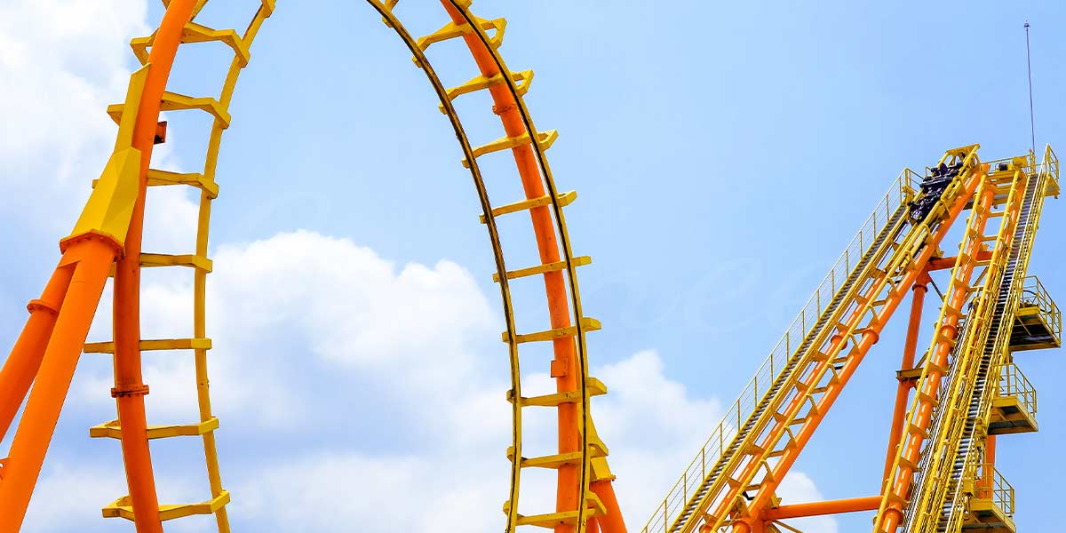 Roller coaster climbing steep track and vertical loop structure in theme park