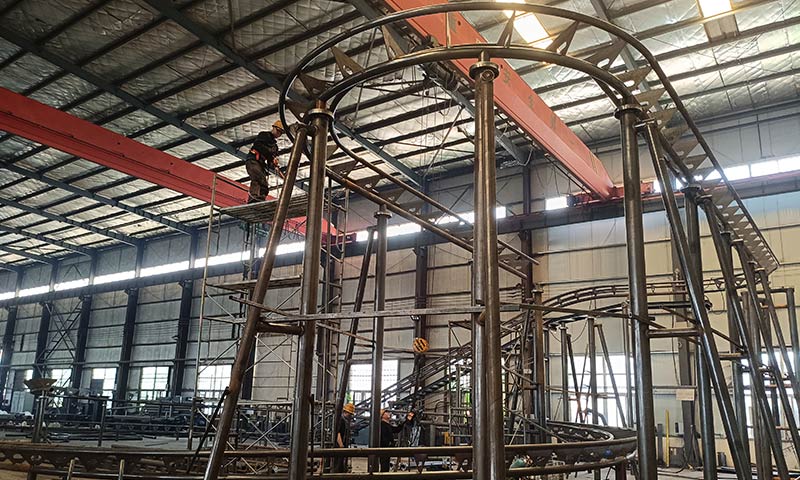Construction of roller coaster structure with steel components being carefully welded and assembled for a stable and safe ride.
