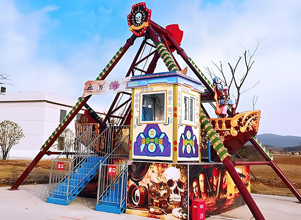 Outdoor small pirate ship amusement ride with control cabin and decorative paintings.