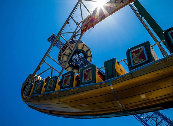 Swinging pirate ship ride under blue sky in amusement park