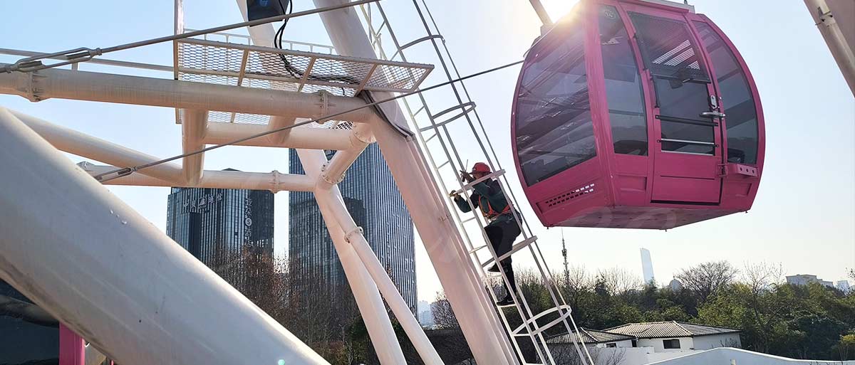 Amusement park ride maintenance: technician climbing a Ferris wheel for inspection, ensuring safe operation and equipment integrity.