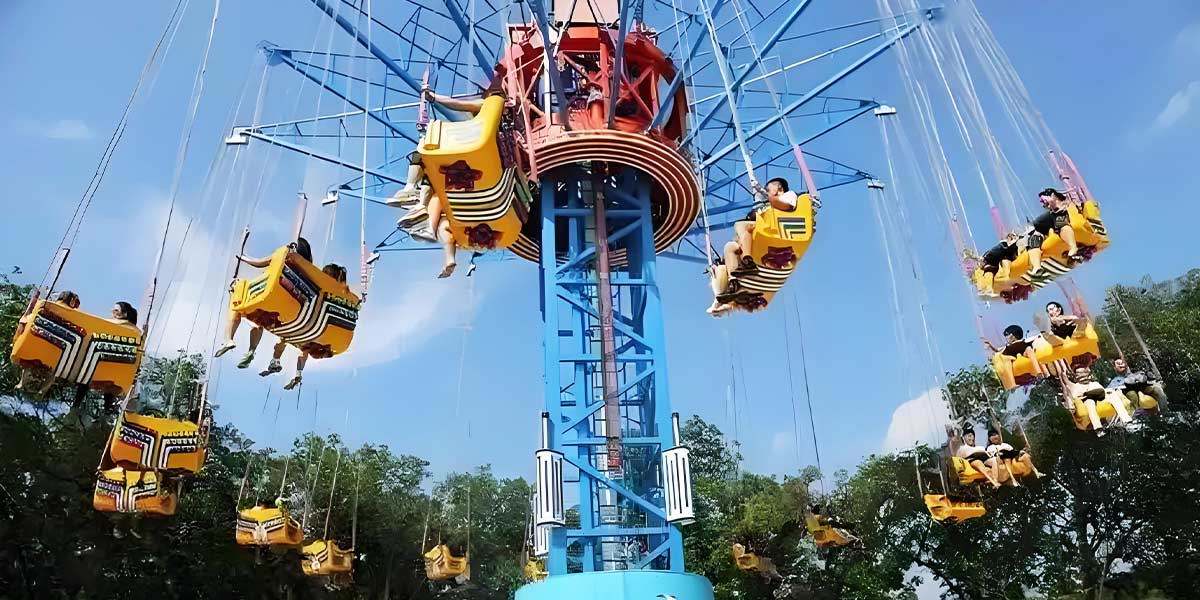 Amusement park swing ride in operation: passengers enjoying the thrill while operators ensure safety and proper functioning of the equipment.