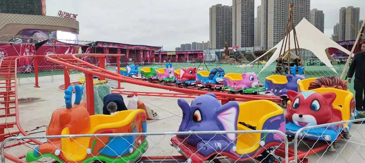 Cartoon animal-themed kids roller coaster with multiple colourful cars