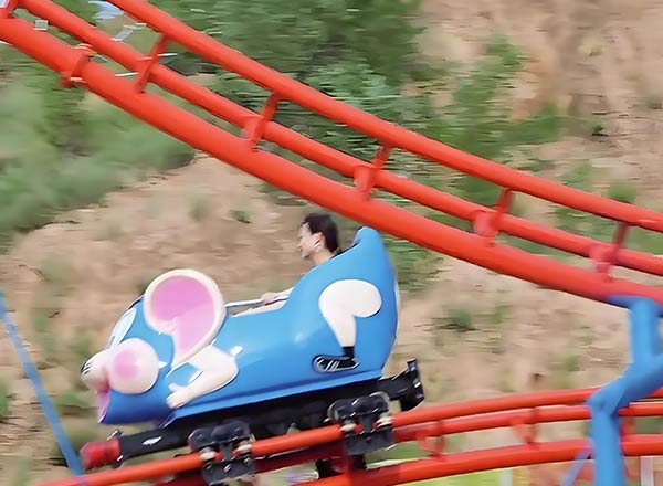 Theme Park Crazy Mouse roller coaster with blue mouse-shaped car on sharp curved track