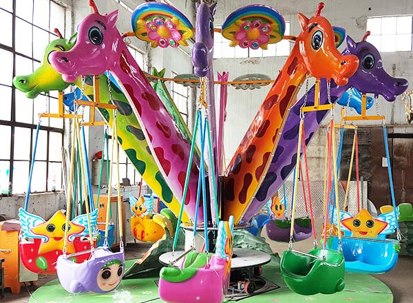 Giraffe-themed carnival swing ride with vibrant giraffe and bird designs, perfect for children's amusement.