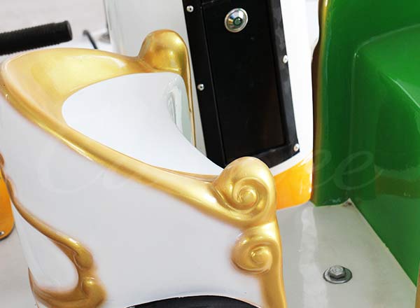 Close-up of mini carousel carriage seat with golden decorative edges, safe and comfortable design for kids.