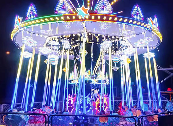 Modern themed swing amusement park ride with neon lights, showcasing the transformation of swing rides into high-tech attractions.