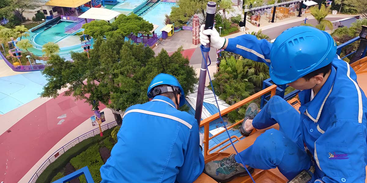 Amusement park technician repairing ride safety equipment with a wrench.