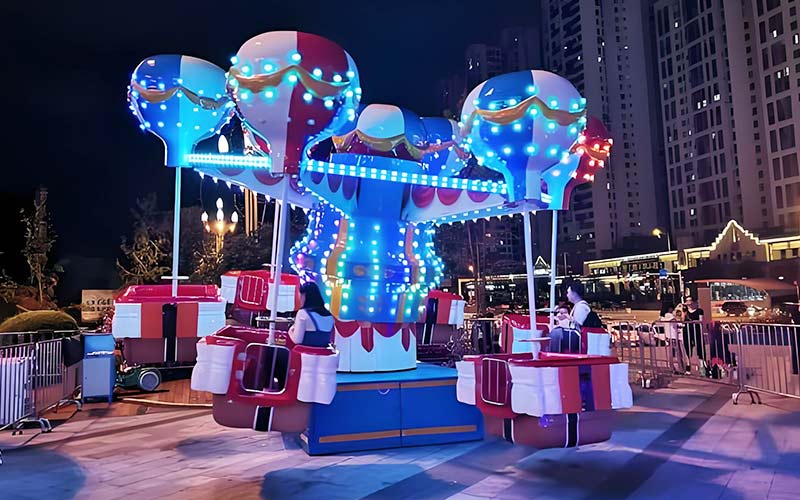 Portable Samba Balloon Ride at a shopping mall night event with glowing LED lights and family riders