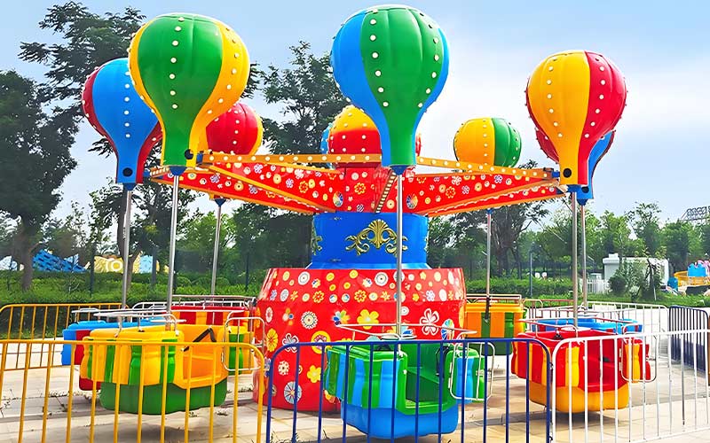 Samba Balloon Ride installed in a large outdoor theme park with colorful balloon gondolas