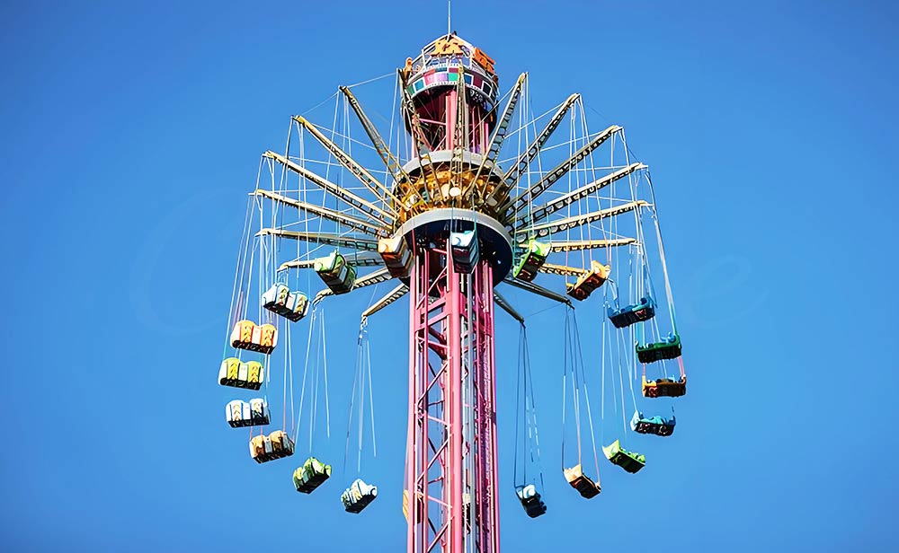 Thrilling Ride Tower swing ride with colorful suspended chairs, providing thrilling high-altitude flying experience in amusement park