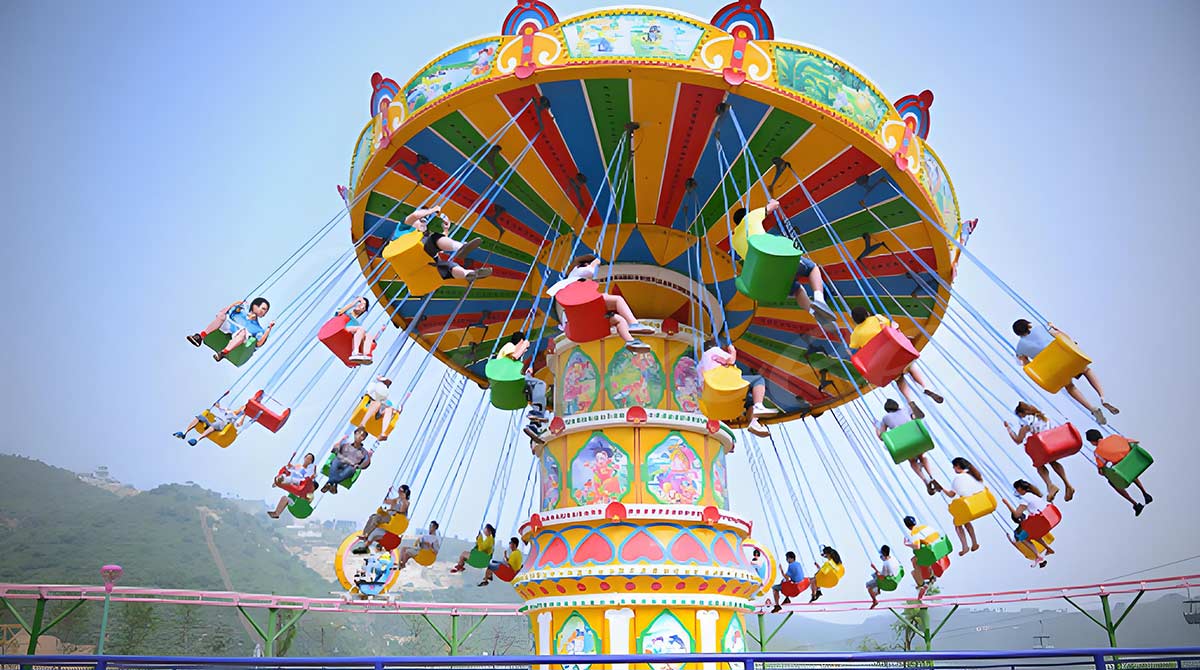 Famille et enfants sur un manège à vagues colorées dans un parc d'attractions en plein air