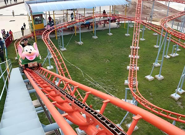 Wild Mouse roller coaster train climbing lift hill on red track before daily maintenance inspection