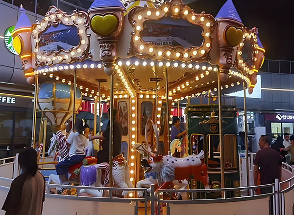 Carousel ride inside shopping mall with colorful lights and fun design, attracting visitors.
