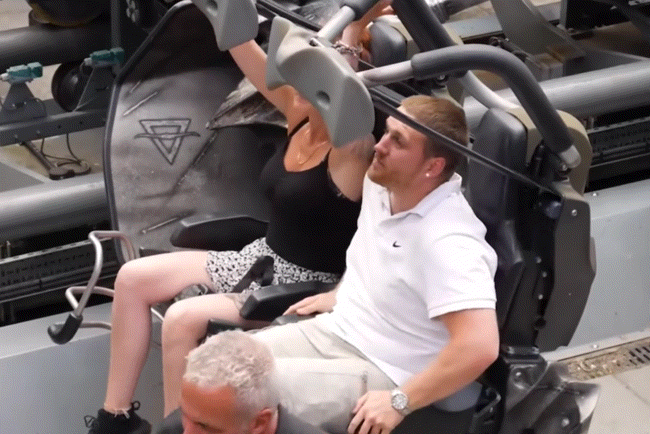 Les passagers attachent le dispositif de retenue par-dessus l'épaule sur les montagnes russes avant le début du tour pour assurer la sécurité.