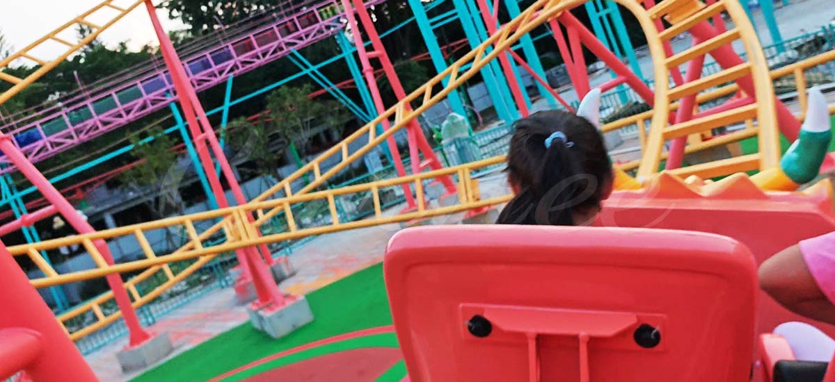 Children riding a colorful family roller coaster made by Carnee Rides Manufacturer, showing fun and safety.