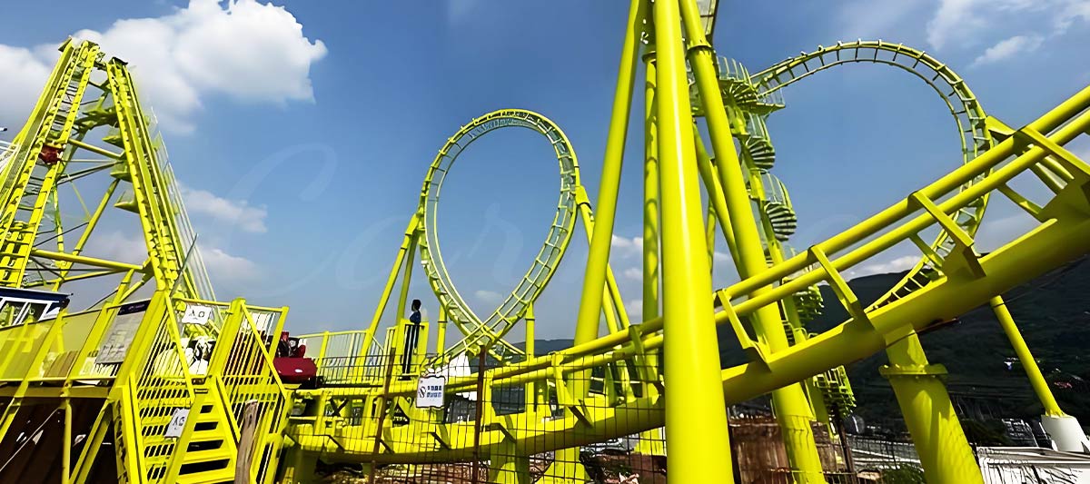 Grandes montagnes russes en acier jaune vif avec boucle verticale et pistes courbes et lisses.