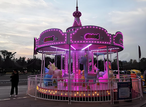 Pink carousel merry go round ride designed for kids at an amusement park, featuring vibrant colors and fun design.