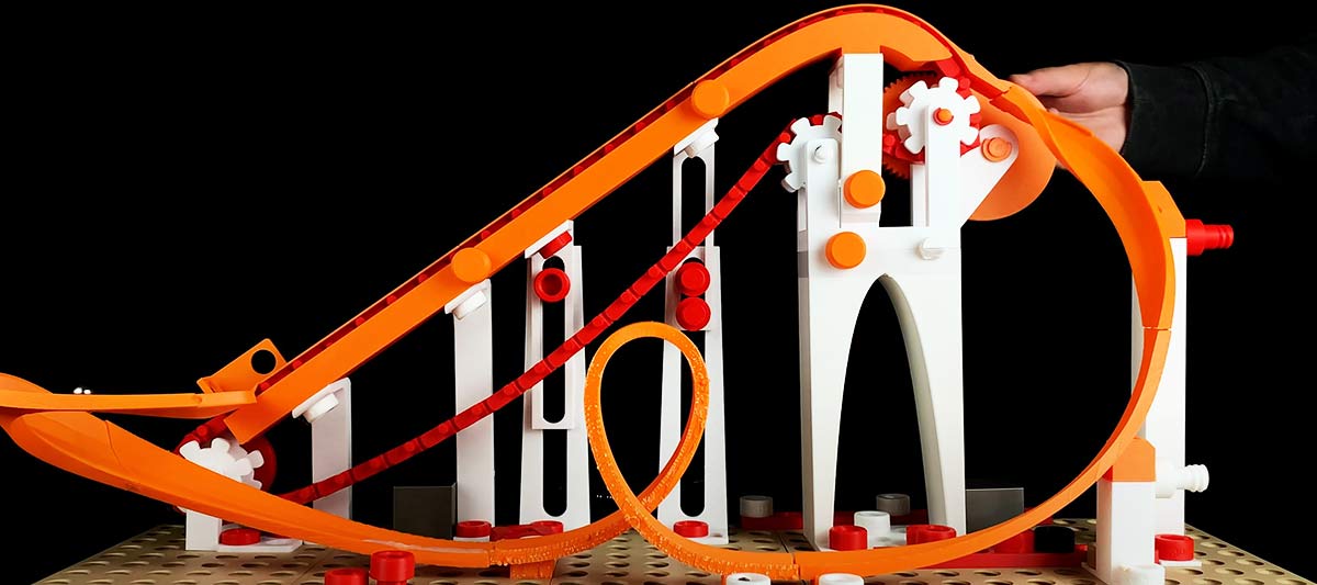 Modèle de démonstration montrant comment les rails et les roues des montagnes russes fonctionnent ensemble pour maintenir le train sur la voie.
