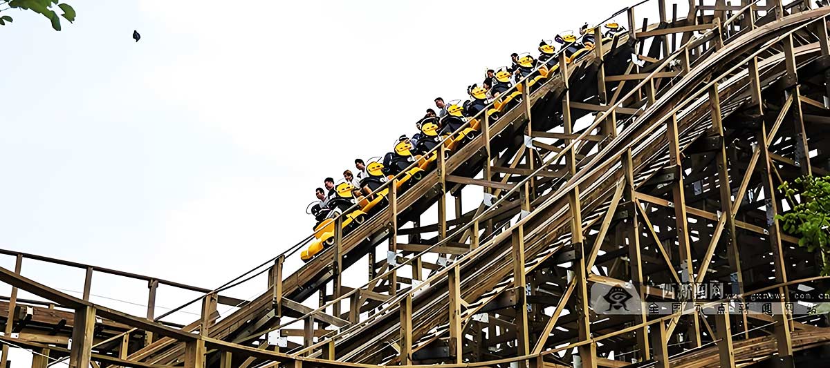Les passagers d'une montagne russe en bois vivent des moments de tension et de suspense sur la piste.