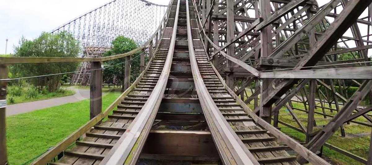 Vue rapprochée d'un rail de montagnes russes en bois montrant la structure et la texture classiques.