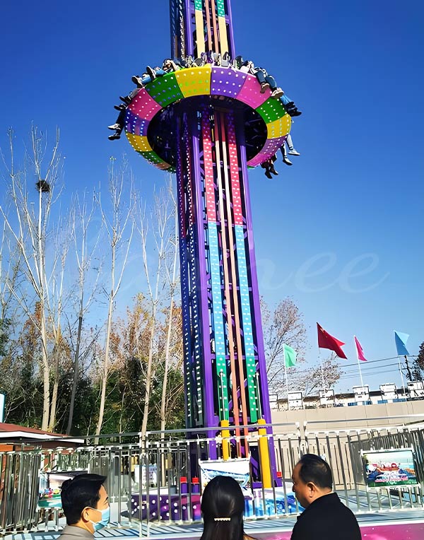 Colorful drop tower carnival ride at an amusement park, offering an exciting and thrilling freefall ride for visitors.