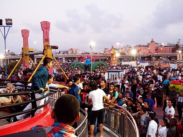 The vibrant 40-seat Disco Tagada ride operating at night in Libya, illuminated by custom LED lighting.