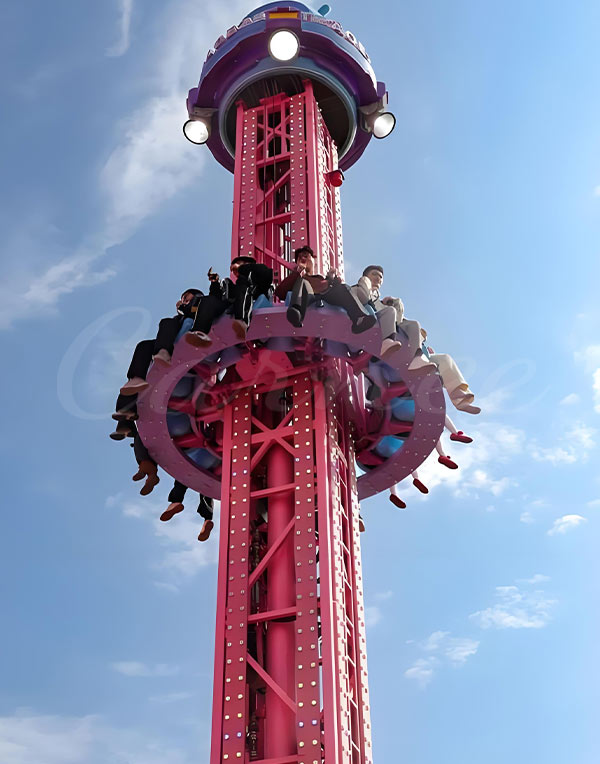 Drop tower ride with passengers at high altitude enjoying thrilling freefall experience at the amusement park.